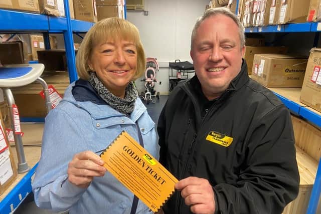 Co-owner Lee Taylor presenting Susan Oversby, 64, with her golden ticket for being the first shopper through the door.