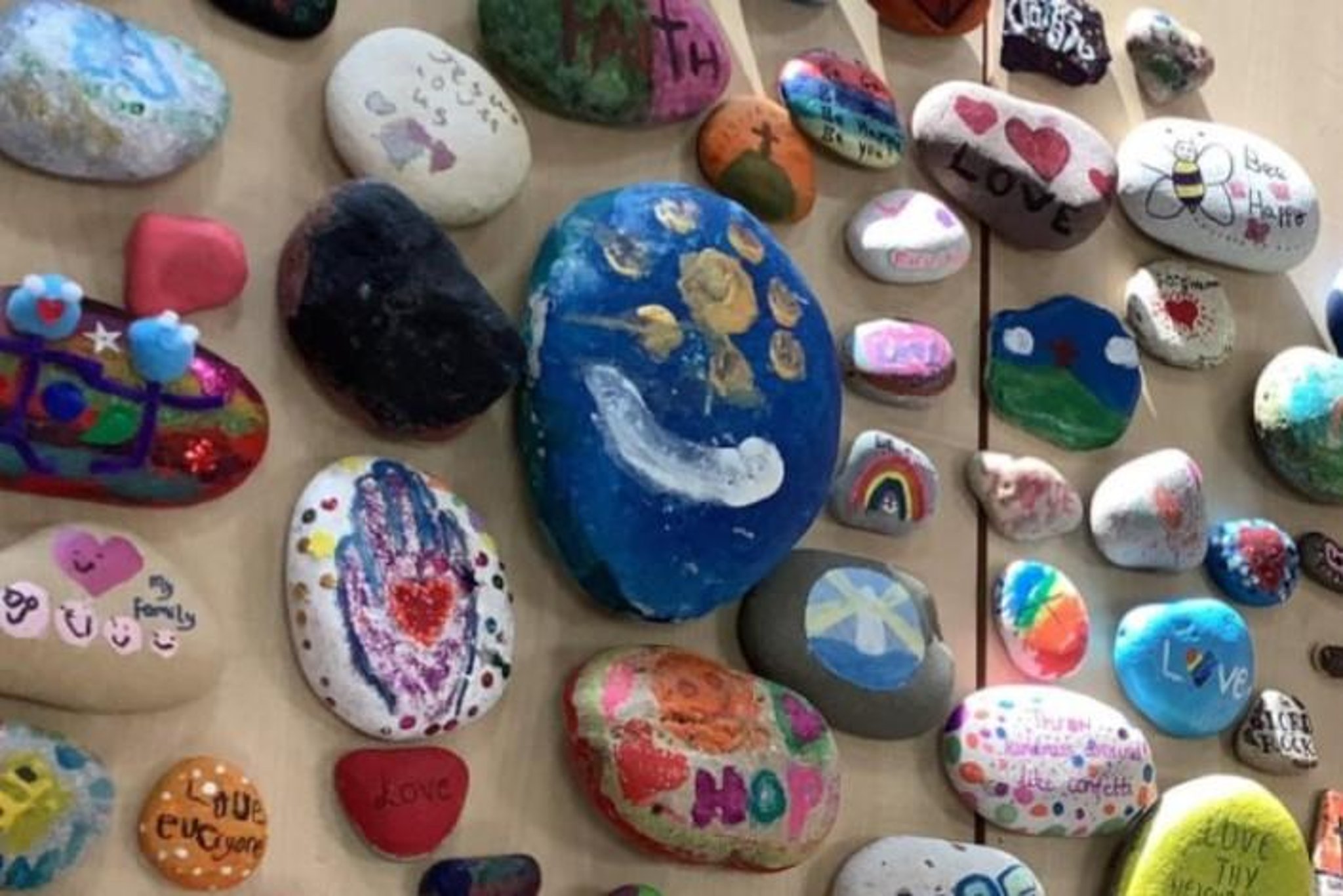 Niños decoran piedras con mensajes que promueven la salud mental positiva