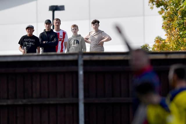 Sunderland fans look over the boundary fence at Oxford United