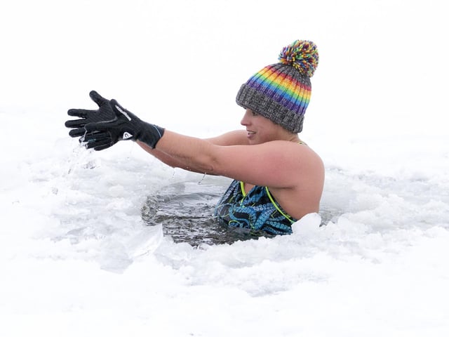 Alice Goodridge plunges through a hole in the ice in Loch Insh, in the Cairngorms National Park.