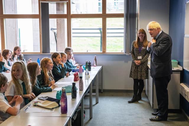 Prime Minister Boris Johnson, wearing the school tie he was presented with on arrival, speaks to a class of Year 7 pupils on their first day back at school during a visit in the East Midlands. Picture: Getty Images.