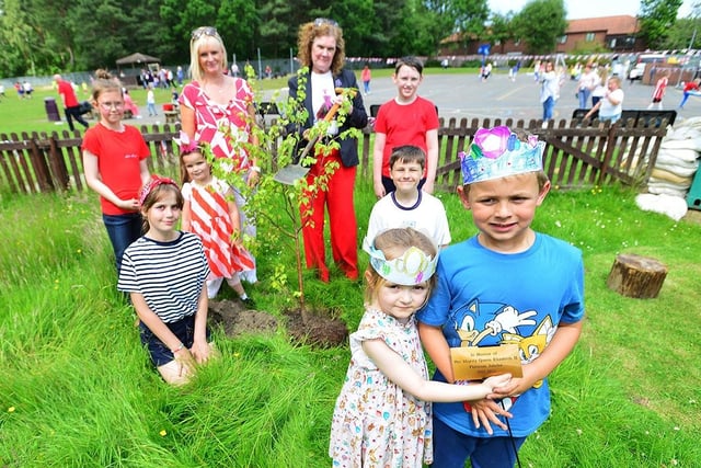 Lampton Primary School headteacher Amanda Defty, left, and Chair of Governors Linda Williams are given a helping hand from pupils Harriet, Harper, Shay, Piper, Ethan, Isla and Lennon as they plant a tree in the school grounds to celebrate the Queen's Platinum Jubilee.
