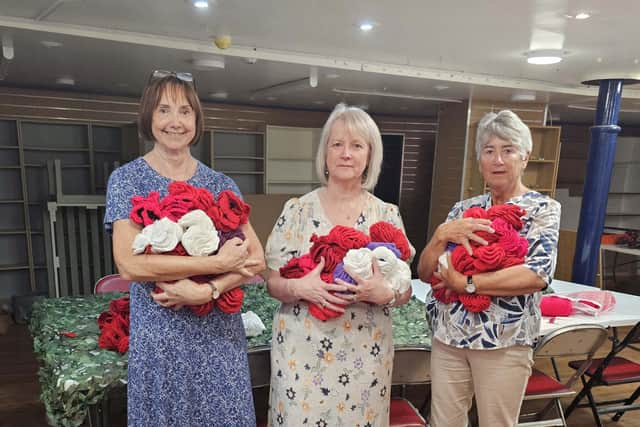 Ladies from the Langley Park Women's Institute hold some of the poppies that they helped make.