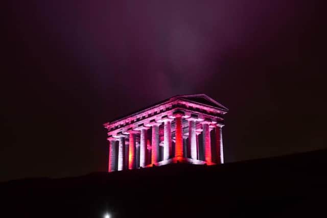 Penshaw Monument lit up in red and white