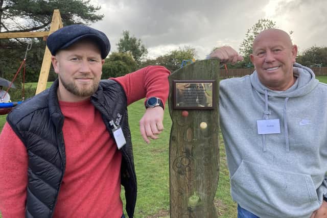 Sandra’s son, Ryan, and husband of 25 years, Michael, with the plaque in her honour at the opening of the new play area at Aycliffe School.