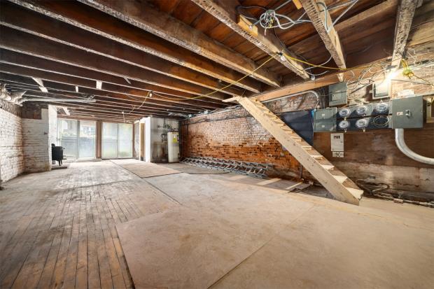 The lower duplex is described as ready for renovation, while the property also includes a standalone three-storey carriage house awaiting restoration.