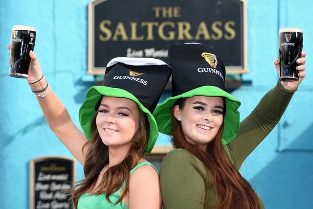 Eden Flanagan and fellow barmaid Erin Green celebrate with a pint of Guinness.