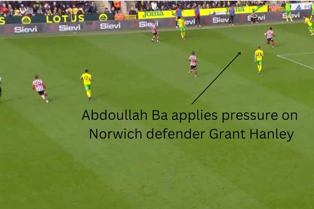 Abdoullah Ba pressing Norwich defender Grant Hanley, who kicks the ball out of play when under pressure.