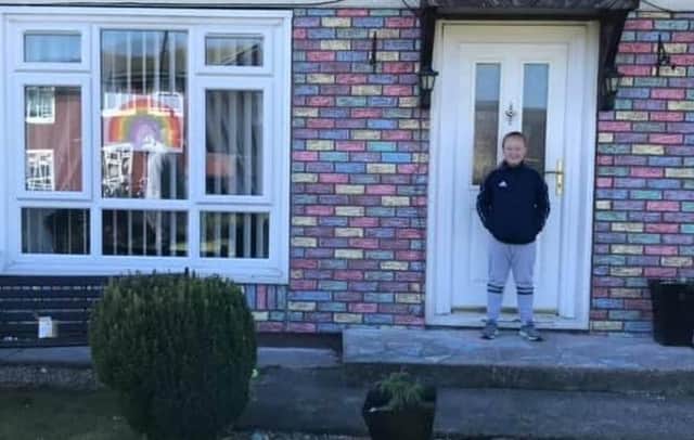 Mia Stevenson, 10, in front of her rainbow-coloured house