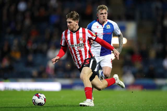 BLACKBURN, ENGLAND - OCTOBER 18: Dennis Cirkin of Sunderland runs with the ball whilst under pressure from Sammie Szmodics of Blackburn Rovers during the Sky Bet Championship between Blackburn Rovers and Sunderland at Ewood Park on October 18, 2022 in Blackburn, England. (Photo by Lewis Storey/Getty Images)
