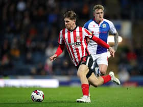 BLACKBURN, ENGLAND - OCTOBER 18: Dennis Cirkin of Sunderland runs with the ball whilst under pressure from Sammie Szmodics of Blackburn Rovers during the Sky Bet Championship between Blackburn Rovers and Sunderland at Ewood Park on October 18, 2022 in Blackburn, England. (Photo by Lewis Storey/Getty Images)
