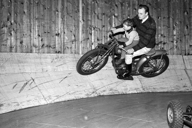 5-year-old Joey Ellis goes for a spin round the base of the Wall of Death with his uncle Al Evans at the Carnival at Waverley Market in 1962.