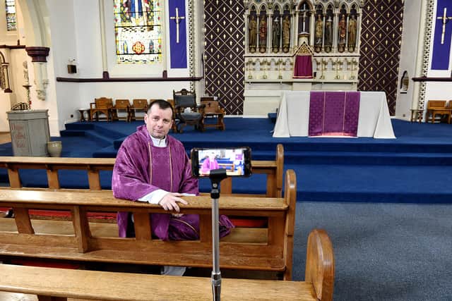 Father Marc Lyden in St Mary’s Church,, Sunderland, next to the camera phone which is streaming masses to the internet.