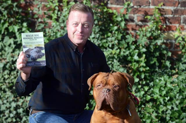 Dog trainer Dom Hodgson with his new book and rescue dog Derek.