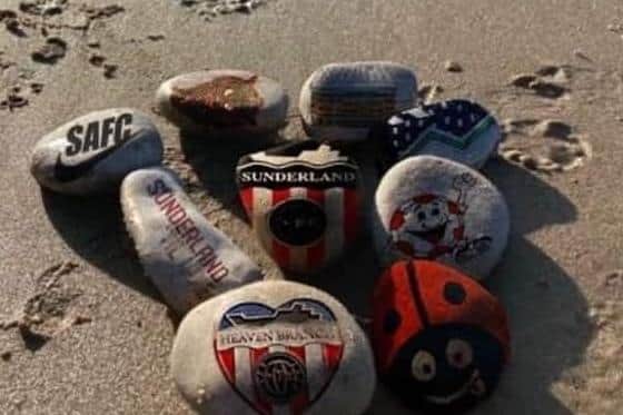 Some pebbles decorated in memory of fans