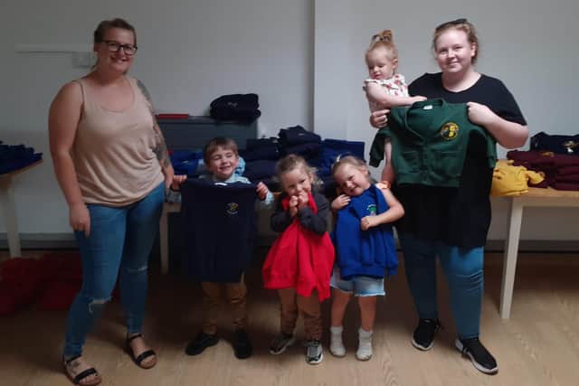 School uniform project coordinator Aimee Jennings (right) with parent Rebecca Neal along with children (left to right) Nate Hetherington, four, Reid Hetherington, three, Ivy Neal, three, and Sienna Scott, two.