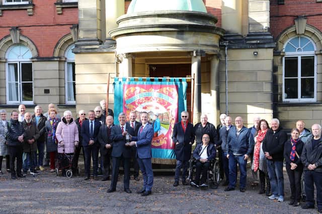 The DMA executive and representatives of the county’s banner groups at the Miners Hall as DMA Secretary Alan Mardghum passes the flame to Chris McDonald, Chair of Redhills CIO.