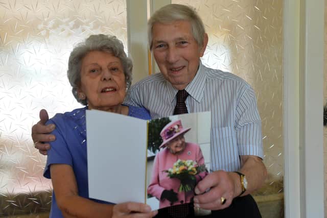 Sheila and John Robson show off the 65th wedding anniversary card they received from the Queen.