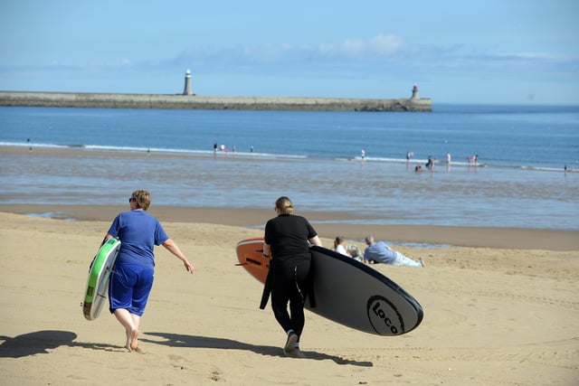 Paddle boarders prepare to cool off at Sandhaven Beach during the heatwave