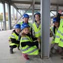 Children from Sunningdale School sign the steel girders which are providing the framework for their new school.