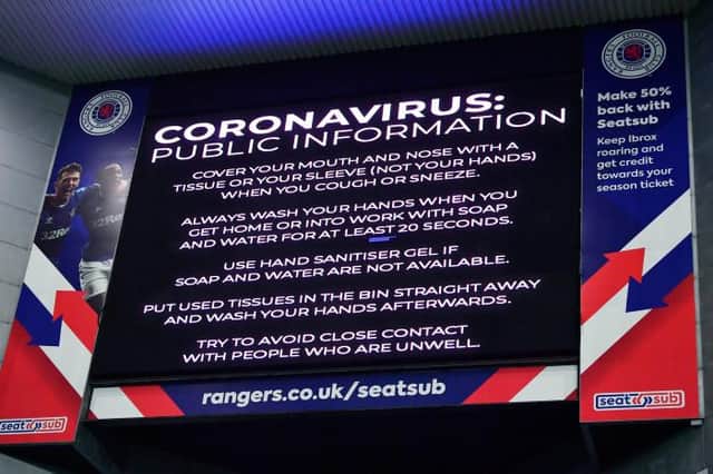 Coronavirus warning notices were prevalent last March - as seen here displayed on the big screens at Ibrox, days before the game was shutdown (Photo by Rob Casey / SNS Group)