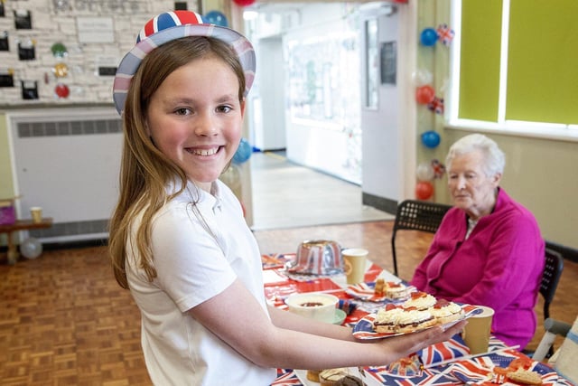 Plains Farm Academy pupil Emily Byers serves up cream scones for the residents of the Village Care Home.