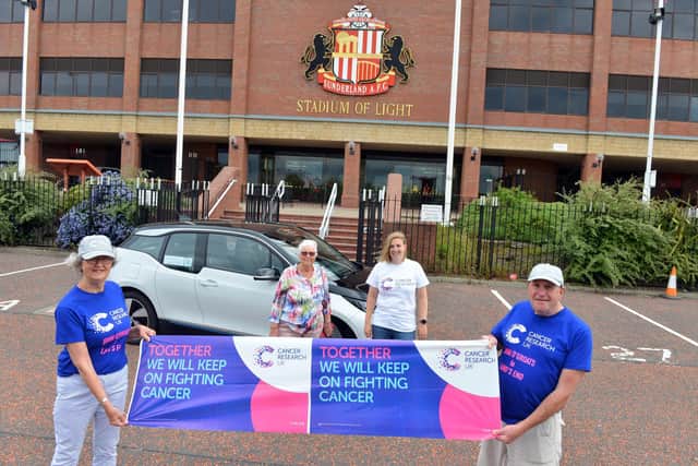 Laila Wesenlund and Eric Bowman are raising money by driving from John O'Groats to Land's End in an electric car. Behind are Greta Hodgson and Claire Waise from Cancer Research UK.