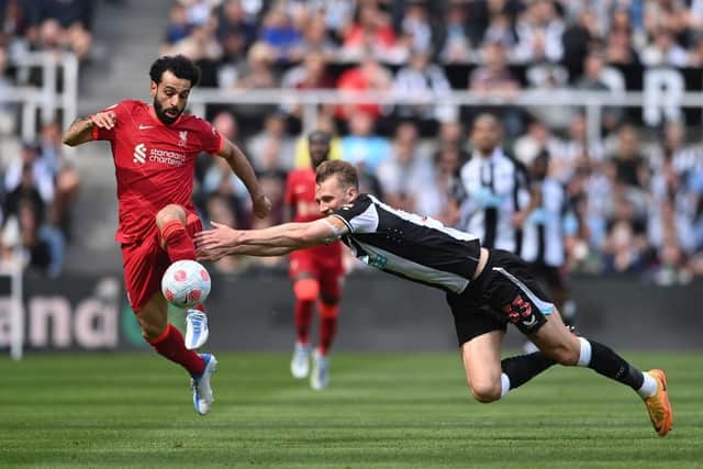 Dan Burn of Newcastle United challenges Mohamed Salah of Liverpool during the Premier League match between Newcastle United and Liverpool at St. James Park on April 30, 2022 in Newcastle upon Tyne, England. (Photo by Stu Forster/Getty Images)