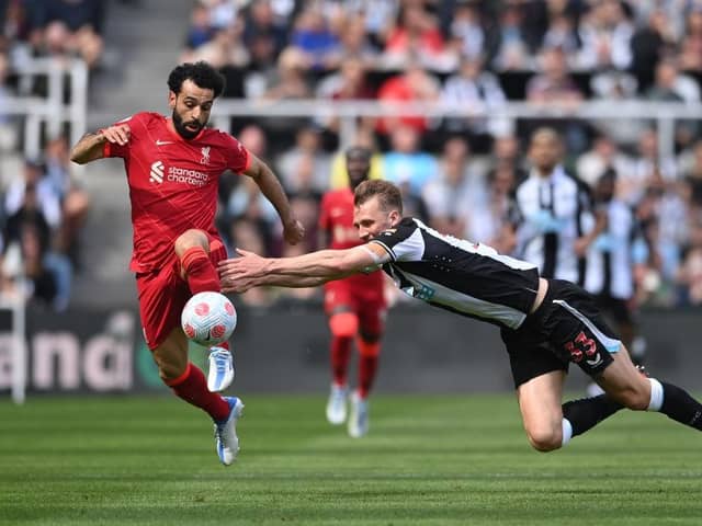 Dan Burn of Newcastle United challenges Mohamed Salah of Liverpool during the Premier League match between Newcastle United and Liverpool at St. James Park on April 30, 2022 in Newcastle upon Tyne, England. (Photo by Stu Forster/Getty Images)