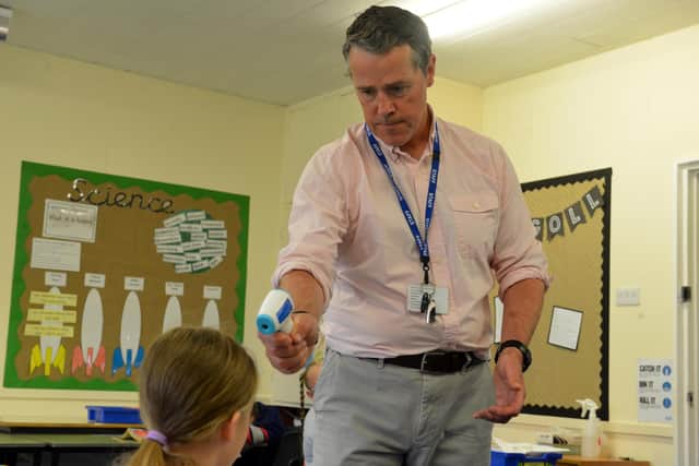 Seaburn Dene Primary School headteacher John Howe checks a pupil's temperature ahead of the school reopening.