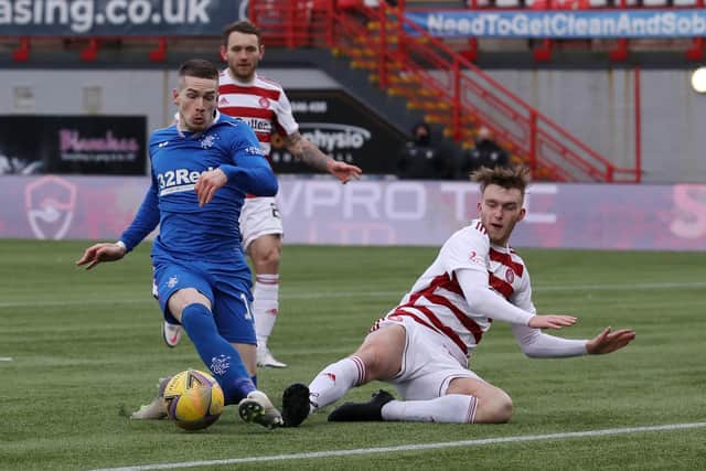 HAMILTON, SCOTLAND - FEBRUARY 07: Ryan Kent of Rangers has an attempt at goal whilst under pressure from Jamie Hamilton of Hamilton Academical during the Ladbrokes Scottish Premiership match between Hamilton Academical and Rangers at Hope CBD Stadium on February 07, 2021 in Hamilton, Scotland. Sporting stadiums around the UK remain under strict restrictions due to the Coronavirus Pandemic as Government social distancing laws prohibit fans inside venues resulting in games being played behind closed doors. (Photo by Ian MacNicol/Getty Images)