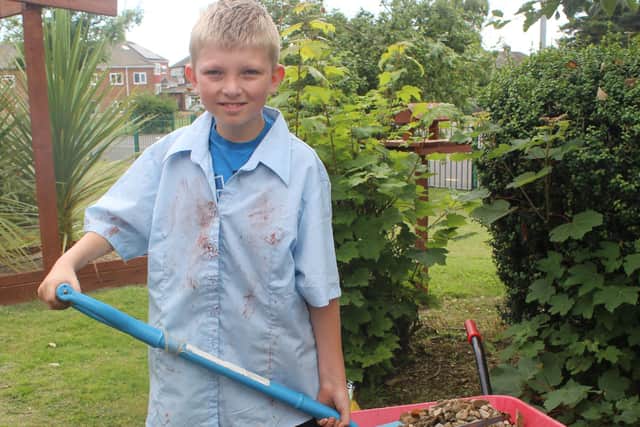 Jason Whitfield, 10, putting stones in plant pots for drainage.
