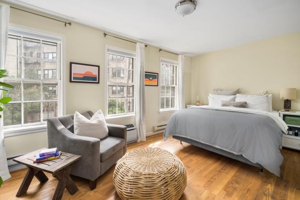Two large bedrooms on the third floor both have three windows spanning the length of the building and share a spacious, skylit, renovated tumbled marble bathroom.