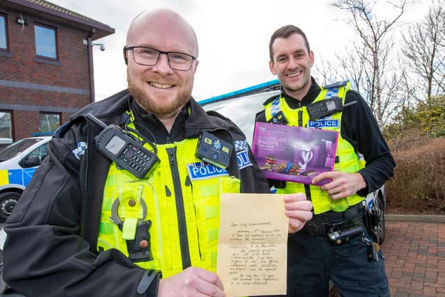 Iain Todd (left) and Sergeant Ed O’Brien with the letter and biscuits sent in by the thankful wife