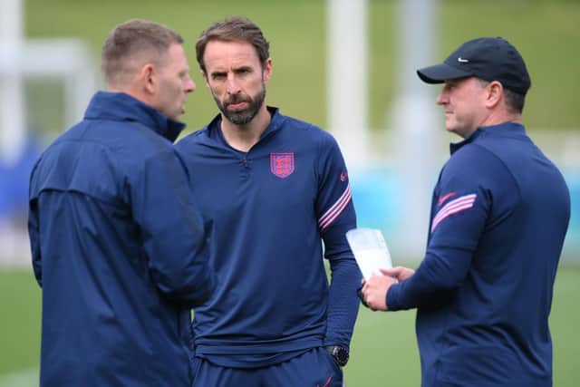 England head coach Gareth Southgate looks on as Graeme Jones and Steve Holland speak in the summer.