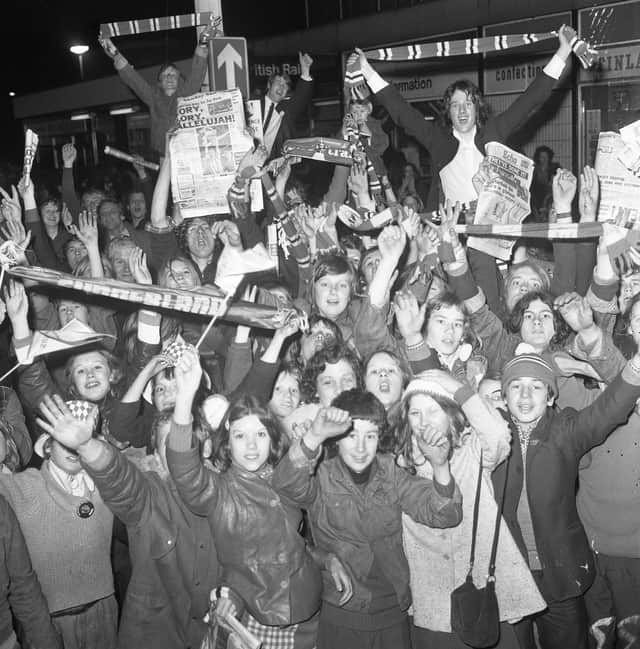 Sunderland fans back at Sunderland station after travelling home from Wembley through the night after the Cup Final win,  holding a copy of the Sunderland Echo.