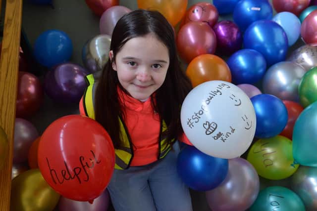 Anti-bullying champion Maisie Riseborough, 11, with some messages of support on her anti-bullying balloons.