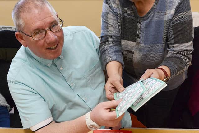 Bingo caller Jean Ogleby sells bingo cards to Michael Taylor (59) at the start of the musical bingo session held at the Sr Thomas Allen Centre. Picture by FRANK REID