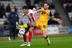 SUNDERLAND, ENGLAND - JANUARY 11: Lincoln player Chris Maguire (r) challenges Tom Flanagan of Sunderland during the Sky Bet League One match between Sunderland and Lincoln City at Stadium of Light on January 11, 2022 in Sunderland, England. (Photo by Stu Forster/Getty Images)