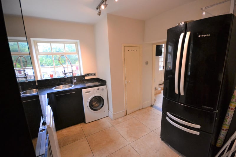 The utility room has granite worktops and contrasting gloss black units, with space and provisions for a washing machine, tumble drier and dishwasher.