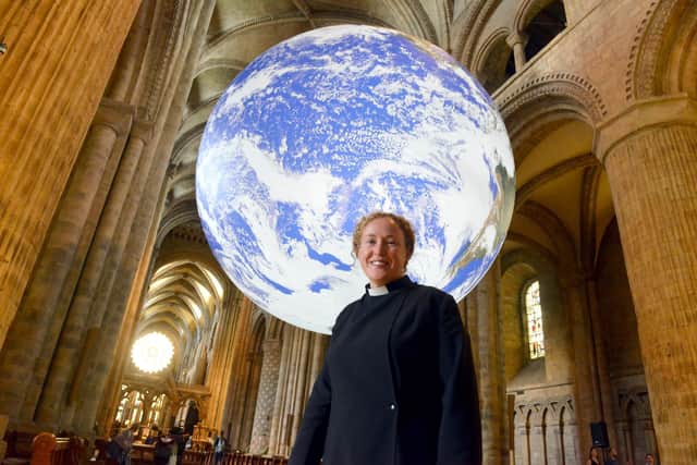 Luke Jerram's giant globe installation Gaia at Durham Cathedral with Revd Canon Charlie Allen.