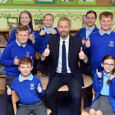 Castletown Community Primary School headteacher Lee Duncan celebrates a good Ofsted report alongside the school's children.