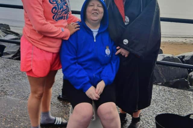 Maggie Lewis, centre, cheered on fundraisers at the sea dip
