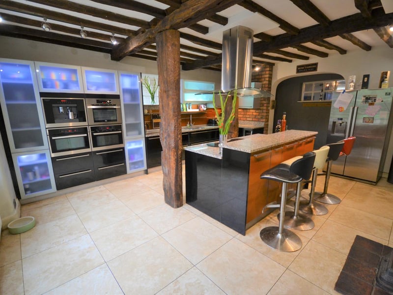The kitchen has an excellent range of bespoke wall and base units finished in gloss back, oak, brushed steel and frosted glass with contrasting granite work surfaces and breakfast bar.