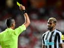 Newcastle's Brazilian midfielder Joelinton (R) is shown a yellow card (Photo by PATRICIA DE MELO MOREIRA/AFP via Getty Images)
