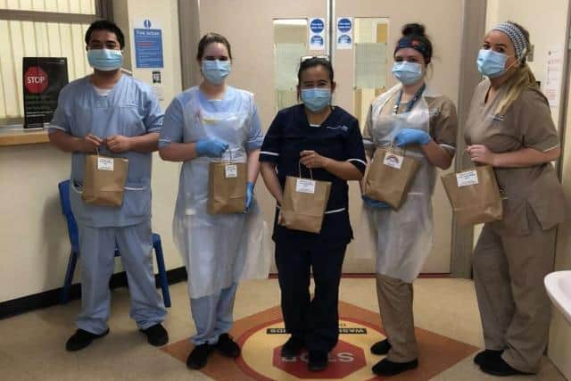 NHS staff can be seen wearing personal protective equipment (PPE) while receiving their packed lunches.