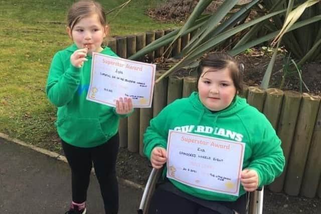 Eva (right) and Ayda Robinson with certificates from a previous fundraising event.