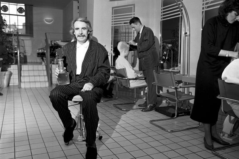 Edinburgh hairdresser Charlie Miller in his salon with the trophy he won at the British Hairdressing Awards in November 1986.