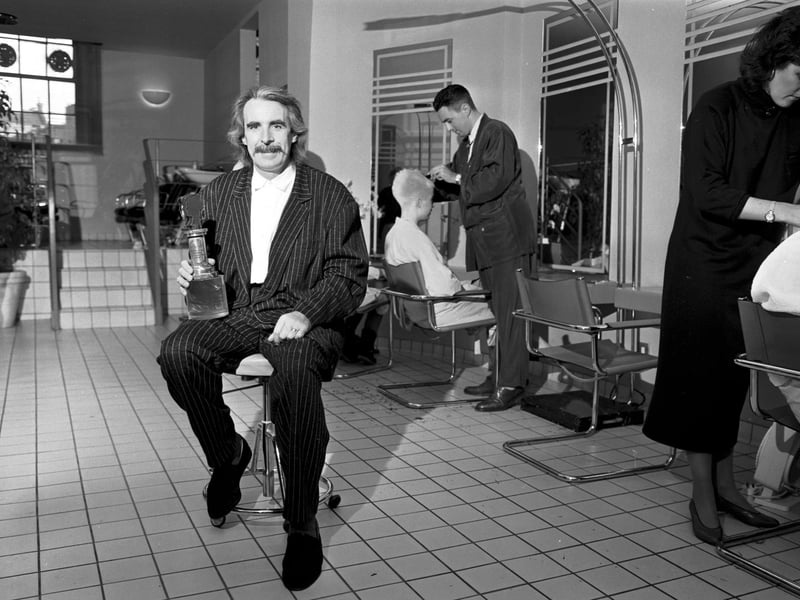 Edinburgh hairdresser Charlie Miller in his salon with the trophy he won at the British Hairdressing Awards in November 1986.