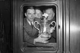 3rd May 1937:  Sunderland captain Raich Carter (Horatio Carter) showing the FA Cup trophy out of the train window at King's Cross station, London, after his team's 3-1 victory over Preston North End in the FA Cup final at Wembley Stadium.  (Photo by J. A. Hampton/Topical Press Agency/Getty Images)